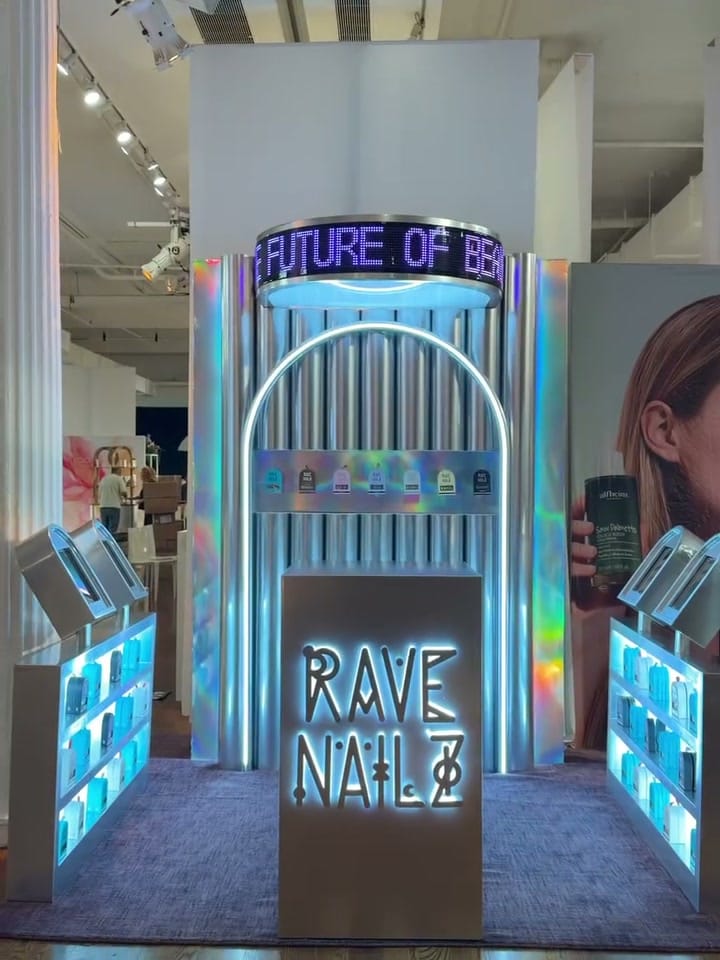 The Rave Nailz booth with its lit-up sign and holographic shelves